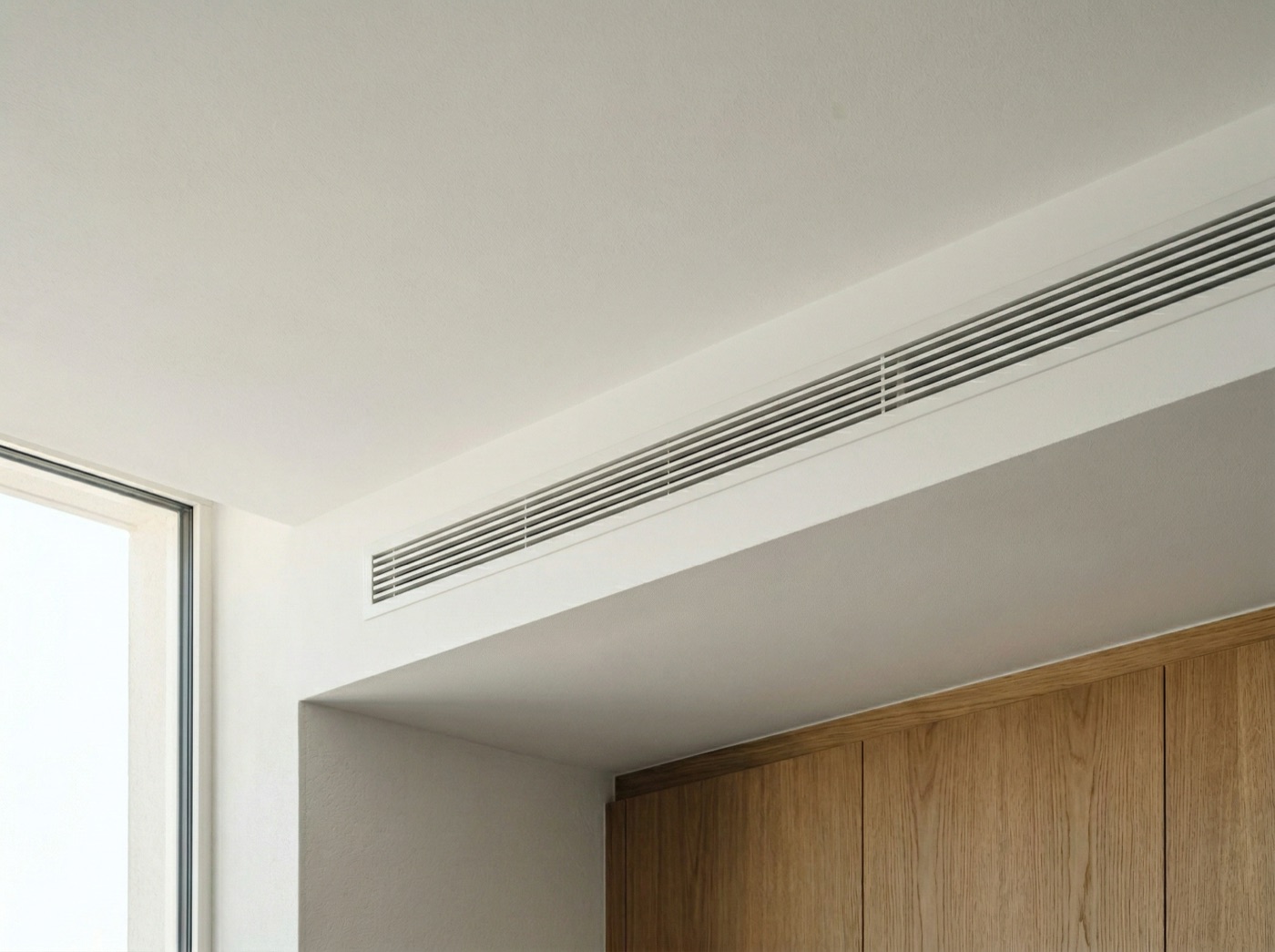 Rejilla lineal integrada discretamente en techo blanco minimalista